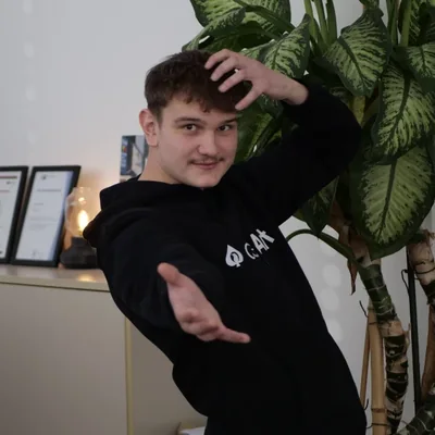 Maximilian Thude, Projektmanager, im schwarzen aceArt-Hoodie im Büro